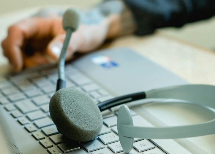 Close-up of a headset on a laptop keyboard, representing remote work and customer support.